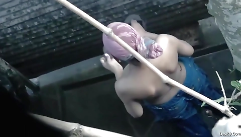 Indian girl bathing with the sun outside in the bath tub